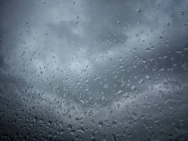 Lluvia cae sobre ventana contra cielo malhumorado — Foto de Stock