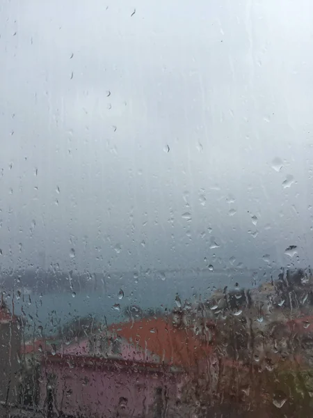 Regen druppels op venster tegen gebouwen in Istanboel, Turkije — Stockfoto