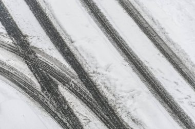 Kışın karlı yol üzerinde lastik izleri
