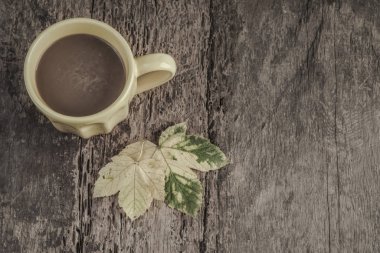 bir fincan kahve ahşap tablo sonbahar yaprakları
