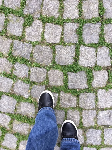 feet walking on cobblestone street