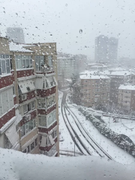 Damla penceresinde şehir görünümü altında karşı kışın kar