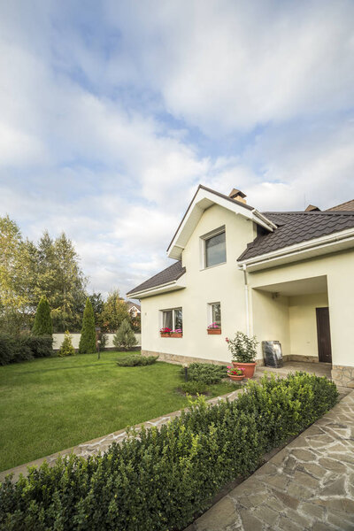 A private house with a garden in a rural area under beautiful sky