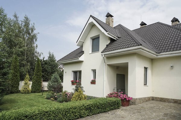 Новый дом с садом в сельской местности под красивым небом
