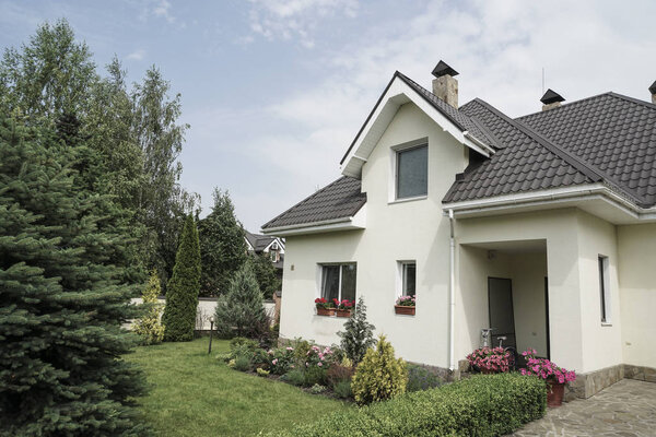 Новый дом с садом в сельской местности под красивым небом
