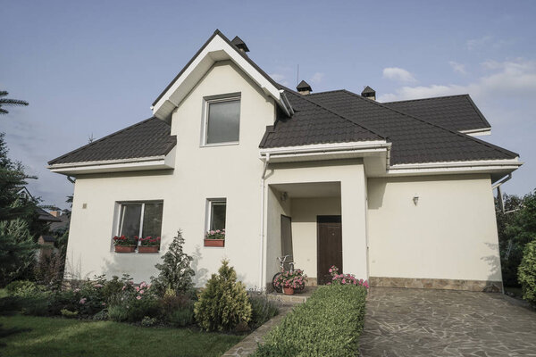 Новый дом с садом в сельской местности под красивым небом
