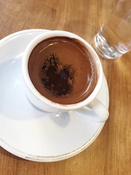 Bir fincan Türk kahvesi ve su cam ahşap tablo