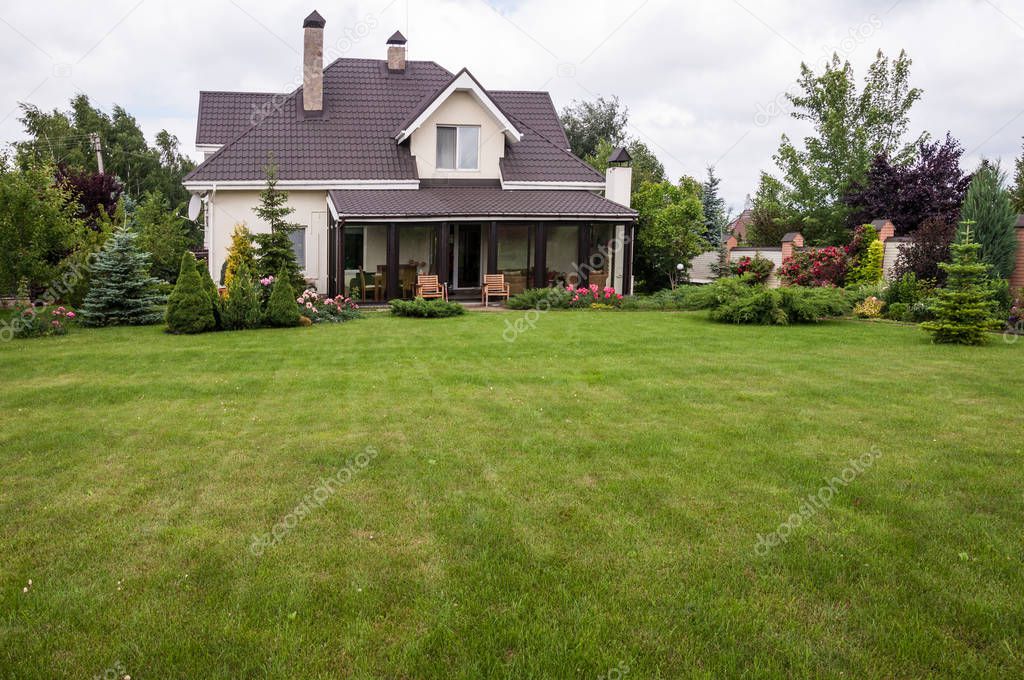 A private house with a garden in a rural area under beautiful sky