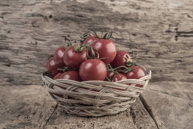 Ahşap masa üzerinde bir sepet içinde olgun domates