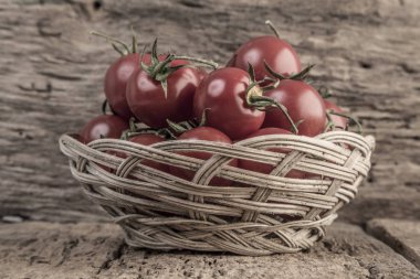 Ahşap masa üzerinde bir sepet içinde olgun domates
