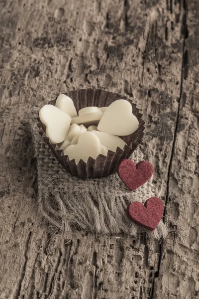 Cioccolatini a forma di cuore su tavolo di legno — Foto Stock