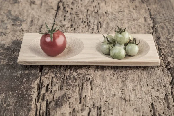Tomates maduros e inmaduros sobre mesa de madera — Foto de Stock