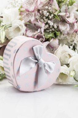 Hediye ve çiçek beyaz üzerinde kalp şeklinde