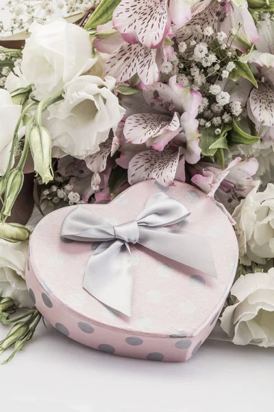 Hediye ve çiçek beyaz üzerinde kalp şeklinde