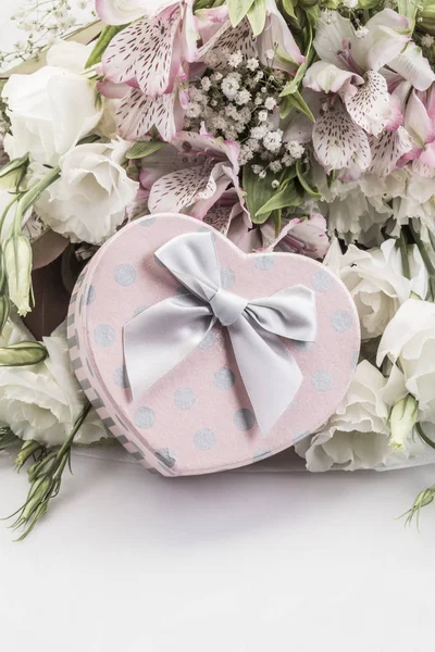 Hediye ve çiçek beyaz üzerinde kalp şeklinde