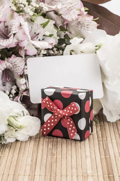 Caja de regalo y flores con una etiqueta vacía — Foto de Stock