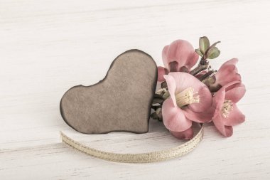 Bahar çiçekleri ve ahşap arka plan üzerinde kalp şeklinde kartı