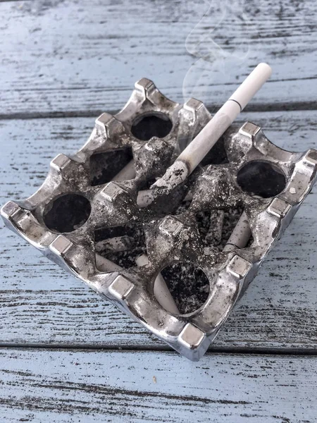 Closeup of cigarette on a silver ashtray — Stock Photo, Image