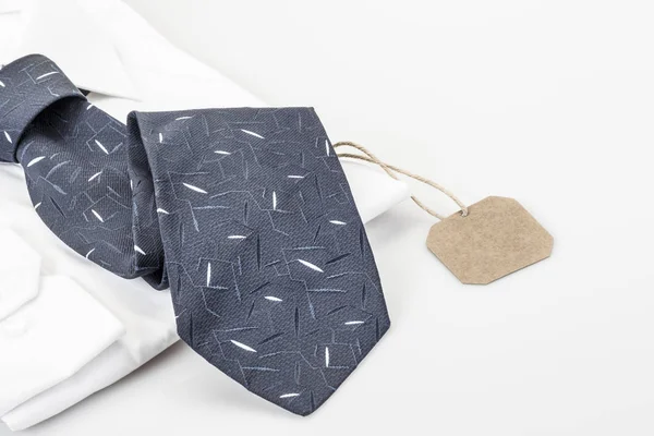 Camisa e gravata azul escuro no branco com uma etiqueta — Fotografia de Stock
