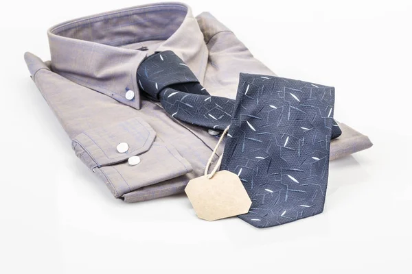 Camisa y corbata azul oscuro sobre blanco con una etiqueta —  Fotos de Stock