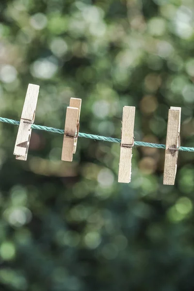 Wooden clothes pegs hanged on rope at garden — Stock Photo, Image