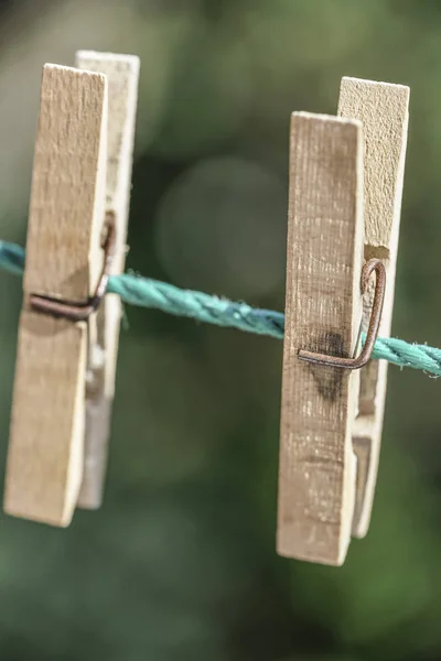 Wooden clothes pegs hanged on rope at garden — Stock Photo, Image