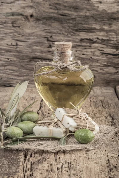 Barras de jabón natural y botella de aceite de oliva en mesa de madera — Foto de Stock