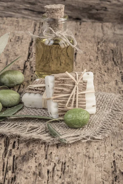 Barras de jabón de aceite de oliva natural y botella de aceite en mesa de madera — Foto de Stock