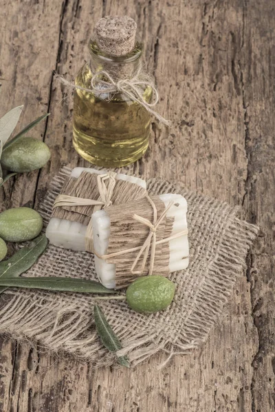 Natural olive oil soap bars and oil bottle on wooden table — Stock Photo, Image