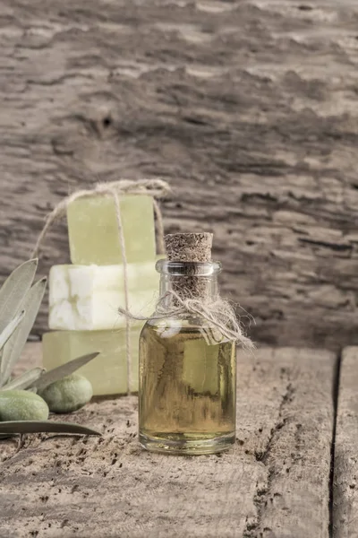 Barras de jabón de aceite de oliva natural y botella de aceite en mesa de madera — Foto de Stock