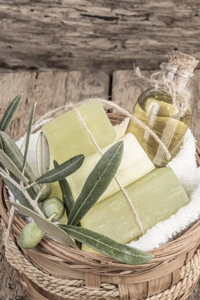 Jabón de aceite de oliva natural y aceite de oliva sobre mesa de madera — Foto de Stock