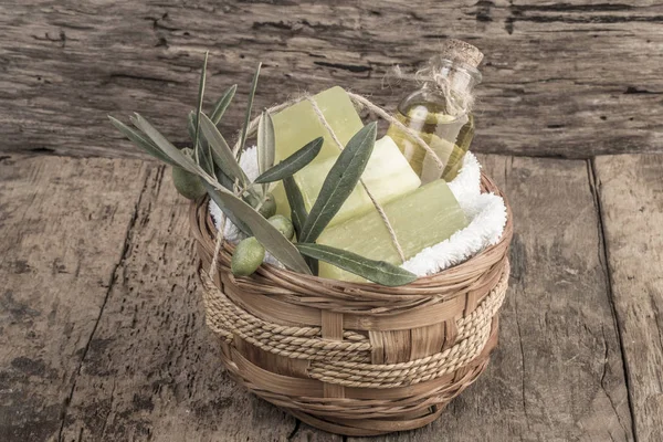 natural olive oil soap bar and olive oil bottle in a basket