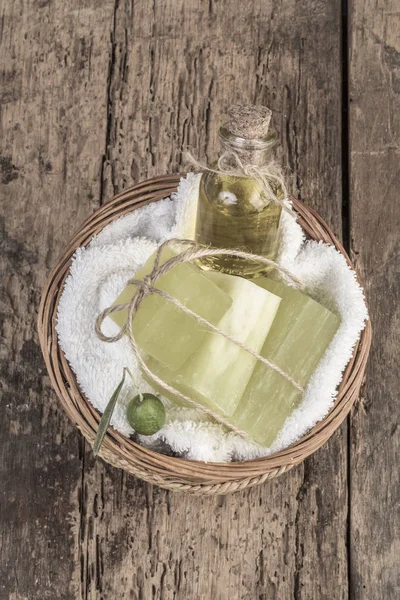 Barras de jabón de aceite de oliva natural y botella de aceite de oliva en una cesta — Foto de Stock