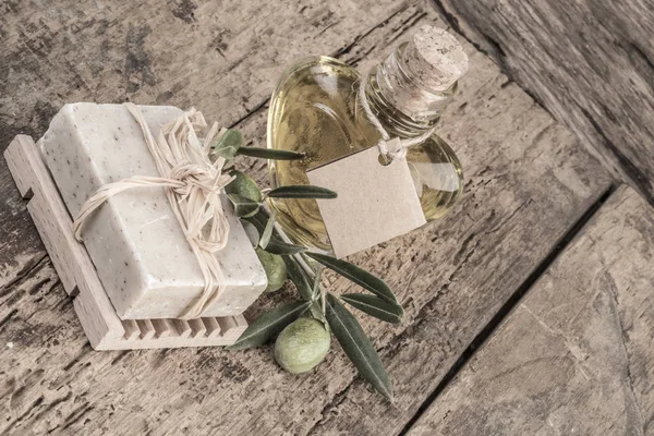 Натуральний мильний бар і пляшка оливкової олії на дерев'яному столі — стокове фото