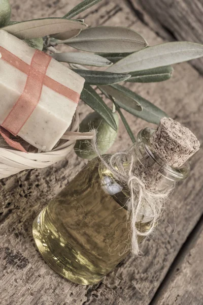 Jabón de aceite de oliva natural y botella de aceite de oliva en mesa de madera — Foto de Stock