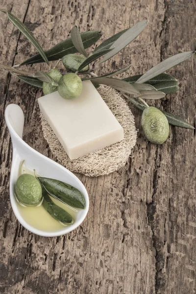 natural olive oil soap and olives on wooden table