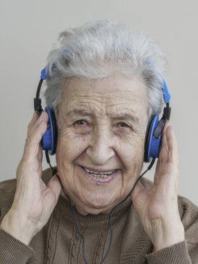 Mutlu kadın kıdemli kulaklık ile müzik dinleme