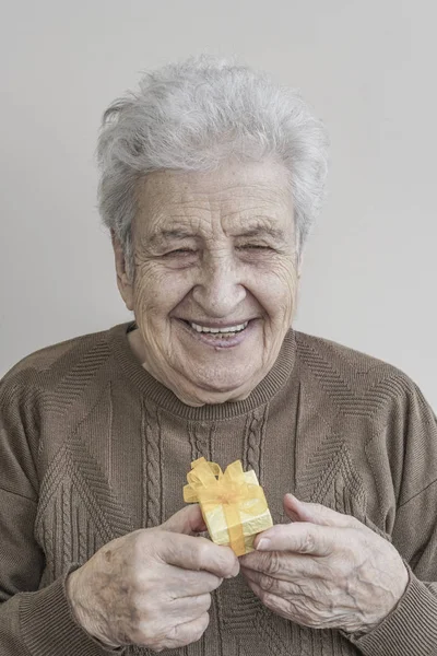 Mujer mayor sosteniendo un pequeño regalo —  Fotos de Stock