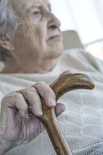 Faltige Hand einer Seniorin am Stock — Stockfoto