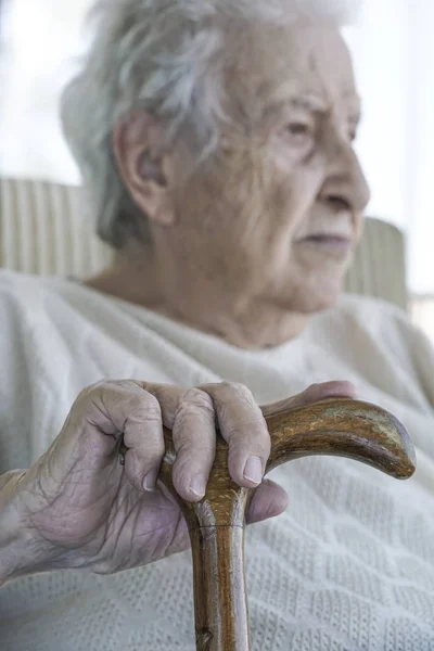 Mão enrugada de uma mulher idosa na cana — Fotografia de Stock