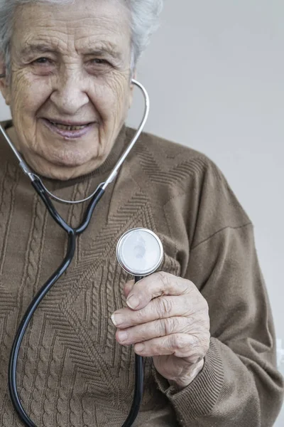 Senior woman holding a stethoscope — Stock Photo, Image