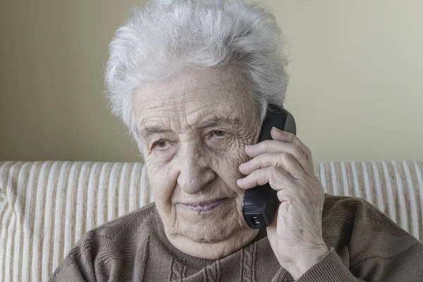 Thoughtful senior woman on phone