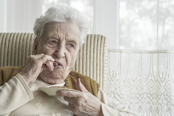 Seniorin isst etwas — Stockfoto