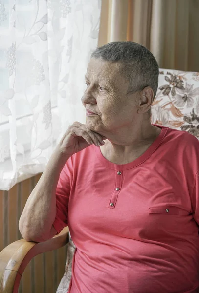Old and happy cancer survivor woman at home after successful chemotherapy