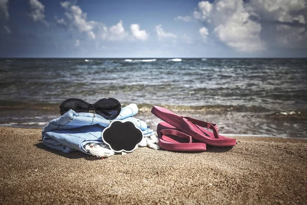 Fondo de verano con chanclas y gafas de sol en la playa — Foto de Stock