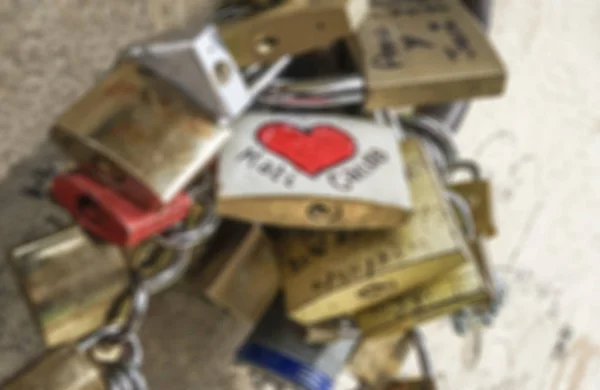 Fondo borroso con candados de símbolo de amor colgados en la pared — Foto de Stock