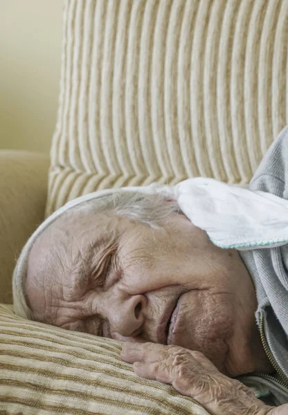 Seniorin schläft auf Sofa — Stockfoto