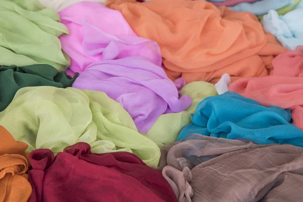 Pilha de roupas coloridas, têxteis como fundo — Fotografia de Stock