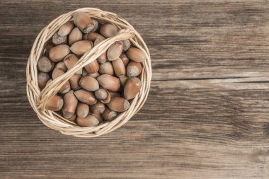 Tahta masadaki sepetin içinde çiğ fındık.