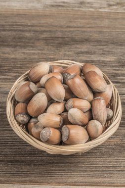 Tahta masadaki sepetin içinde çiğ fındık.